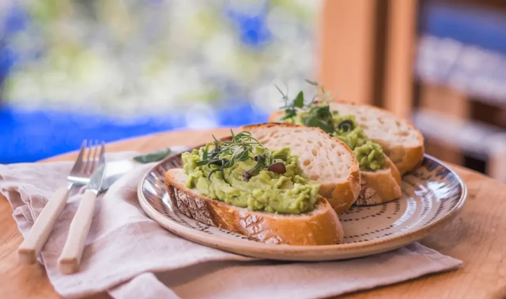 Sliced sourdough bread on a plate with a side of avocado
